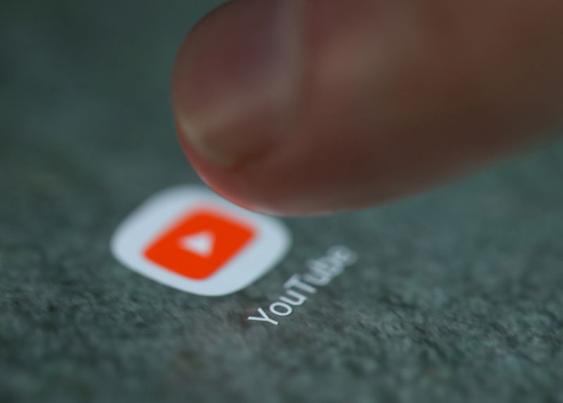 The YouTube app logo is seen on a smartphone in