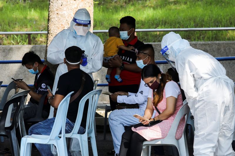 FILE PHOTO: Medical workers speak to people outside a coronavirus