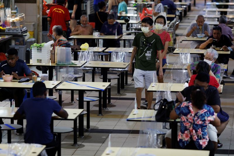People eat at a hawker centre during the coronavirus disease