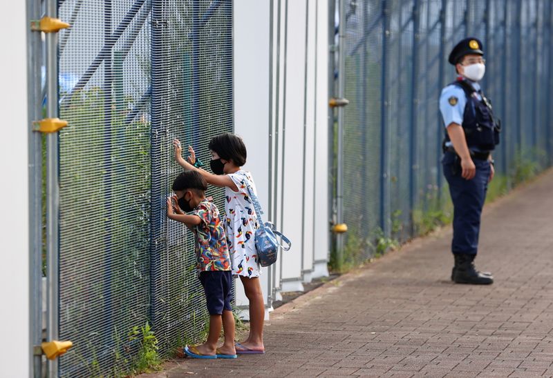 Children look through fence of Aomi Urban Sports Park in