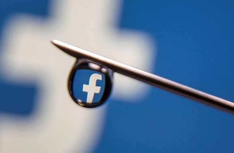 Facebook logo is reflected in a drop on a syringe