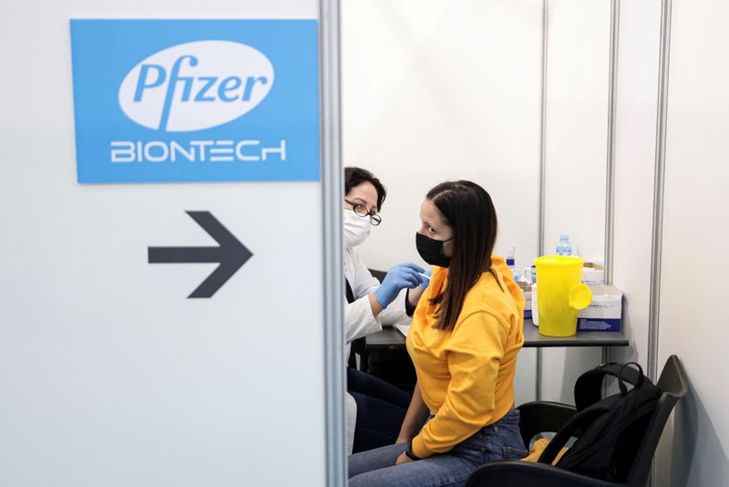 FILE PHOTO: A healthcare worker administers a dose of Pfizer’s