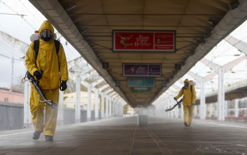 FILE PHOTO: Specialists sanitize a railway station amid the outbreak