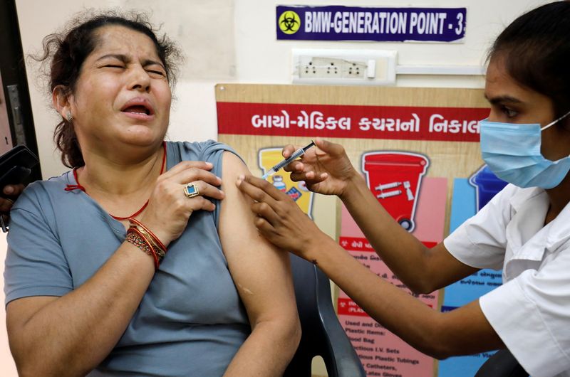 A woman reacts as she receives a dose of the