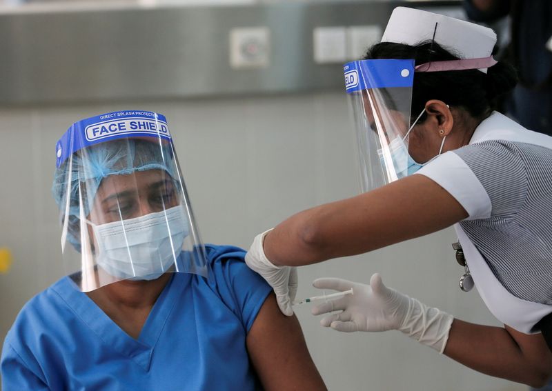 A health official receives a dose of AstraZeneca’s COVID-19 vaccine