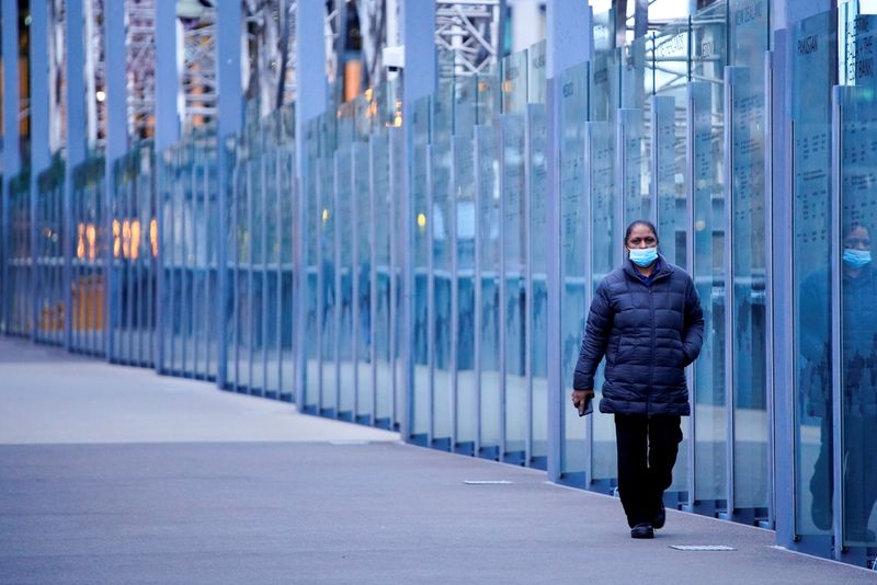 FILE PHOTO: A woman walks along a city bridge a