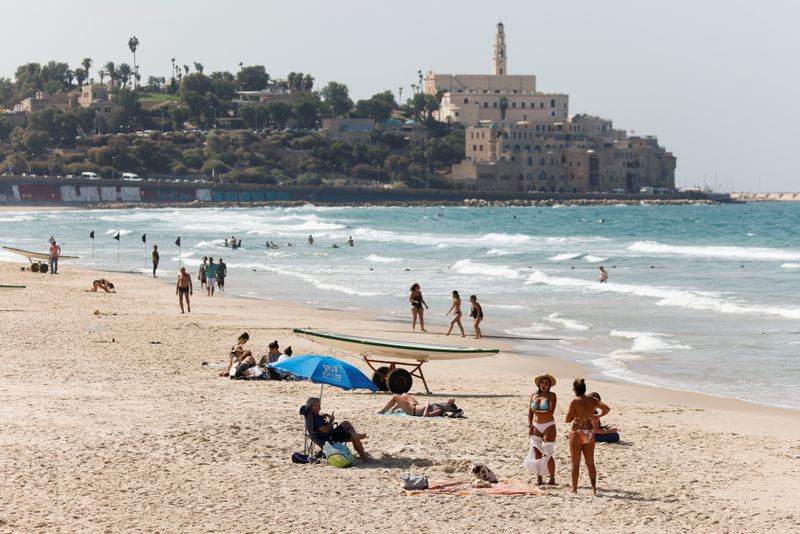 FILE PHOTO: People hang out at the Mediterranean beach near