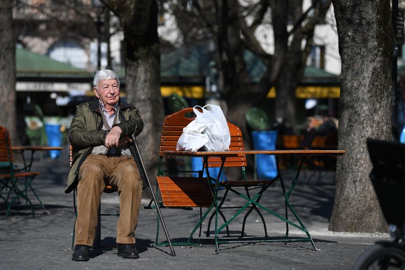 An elderly man sits at the “Viktualienmarkt” daily food market