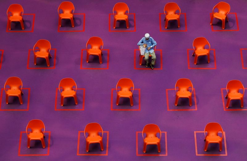 A man sits amongst empty seats at a free movie