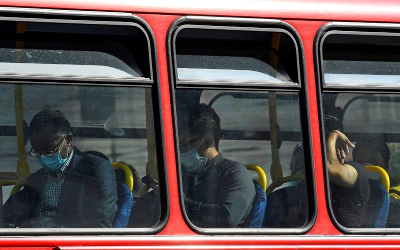 Passengers wear protective face coverings on a London bus, whilst
