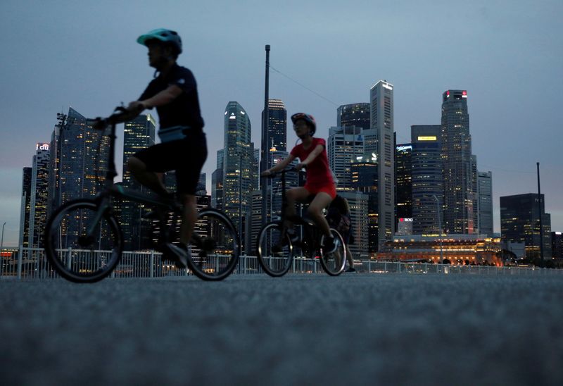Cyclists pass the city skyline during the COVID-19 outbreak, in