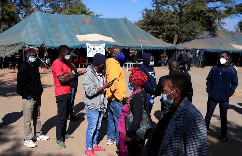 FILE PHOTO: People queue to recieve COVID-19 vaccinations at a