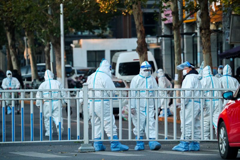 Security personnel in protective suits guard the perimeters of a