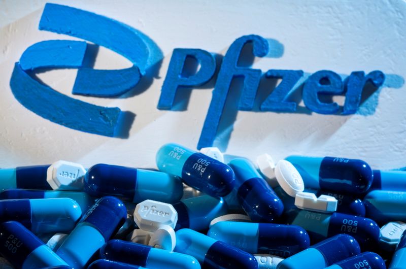 A 3D printed Pfizer logo is placed near medicines from