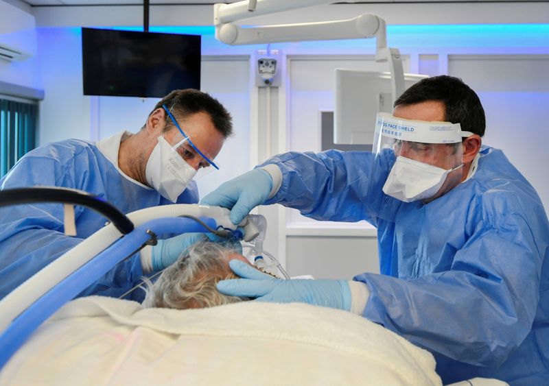 FILE PHOTO: Medics treat a patient infected with COVID-19, in