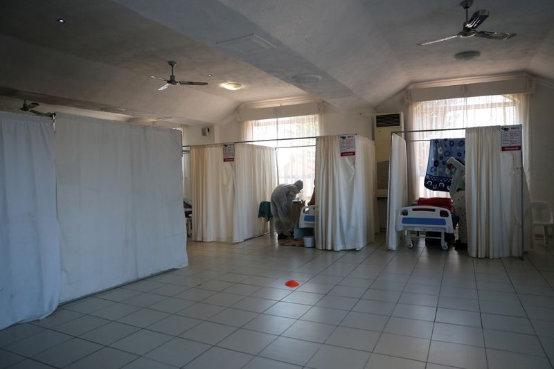 FILE PHOTO: Healthcare workers assist patients being treated at a