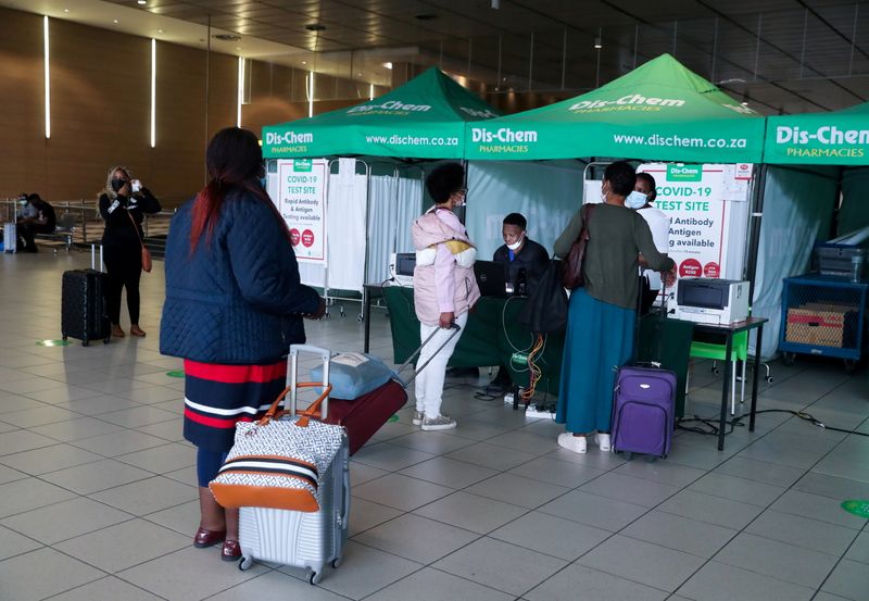 FILE PHOTO: Passengers queue to get a PCR test against