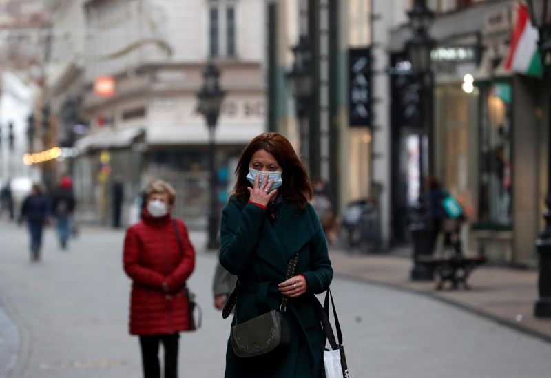 FILE PHOTO: People wearing protective face masks walk in downtown