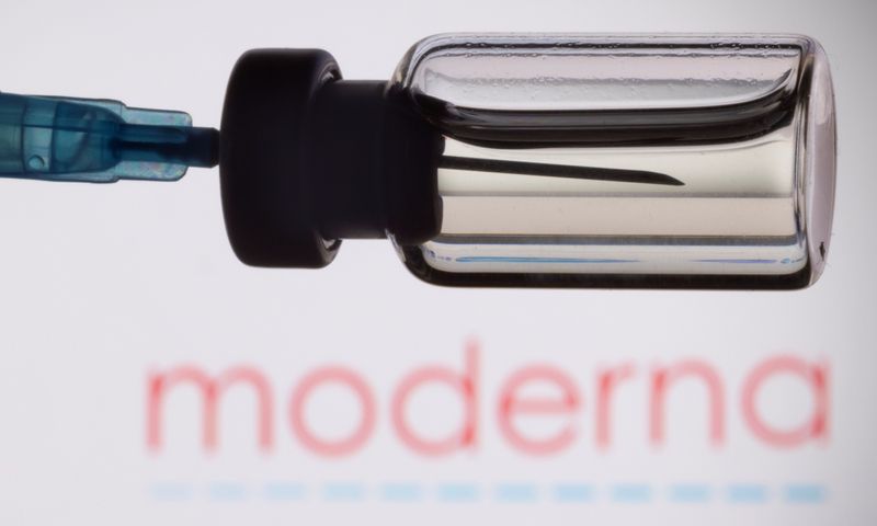 A vial and a syringe are seen in front of