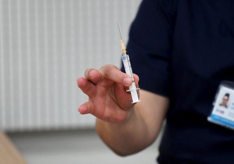 A medical worker holds a syringe with the Pfizer-BioNTech coronavirus