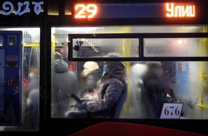 A passenger wears a face mask in a bus amid