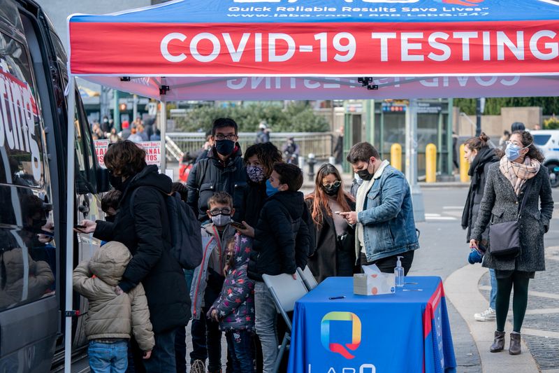 FILE PHOTO: People queue at a popup COVID-19 testing site