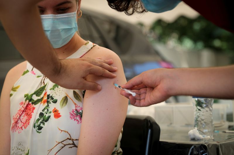 Healthcare worker administers the coronavirus disease (COVID-19) vaccine to a