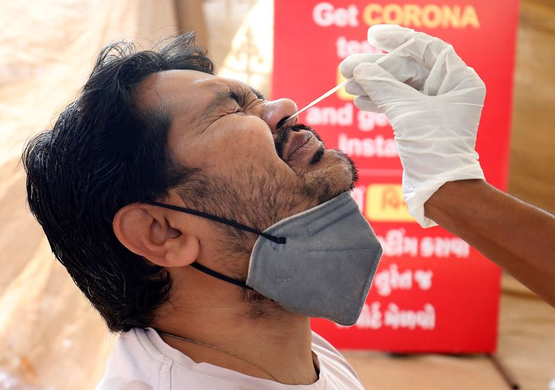 Man reacts as healthcare worker collects swab sample for COVID-19