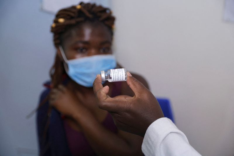 FILE PHOTO: A health worker shows a woman a vial