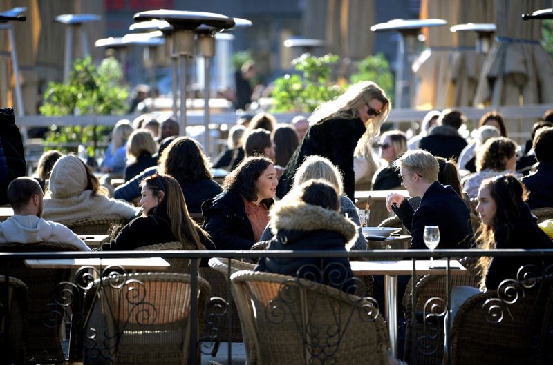 FILE PHOTO: People enjoy the sun at an outdoor restaurant,