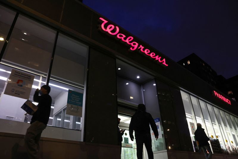 People walk by a Walgreens, owned by the Walgreens Boots