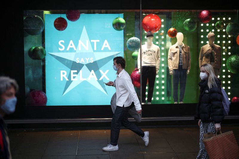 People walk past a Christmas shop display on Oxford Street,