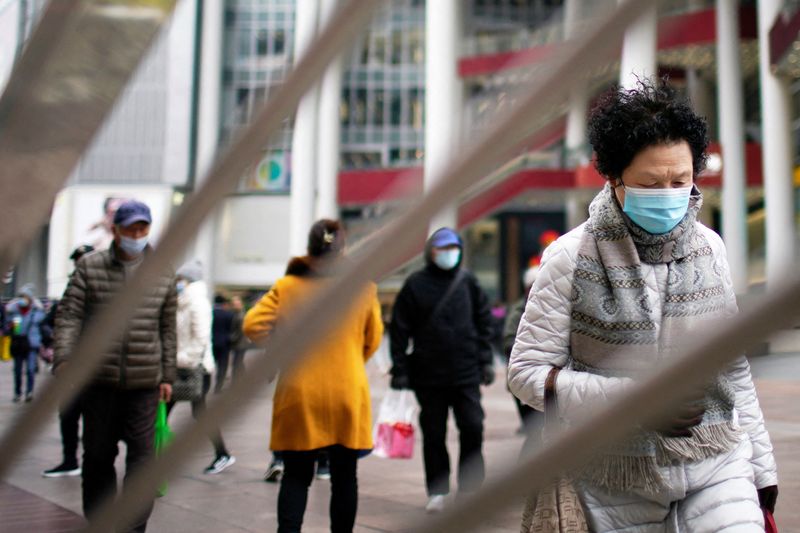 People wearing face masks following the COVID-19 outbreak walk on