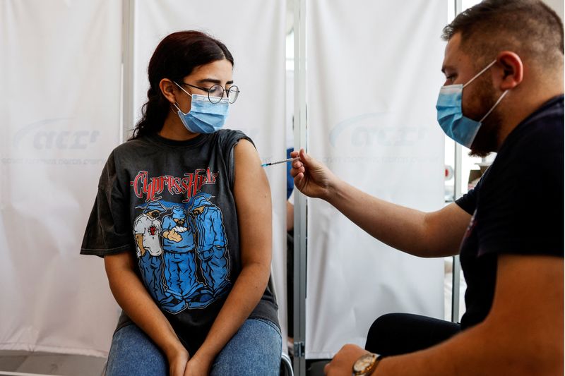 An Israeli woman receives a third shot of coronavirus disease