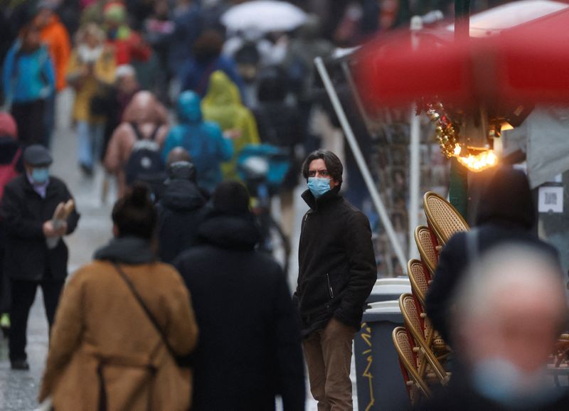 People wearing protective face masks are pictured in a street,