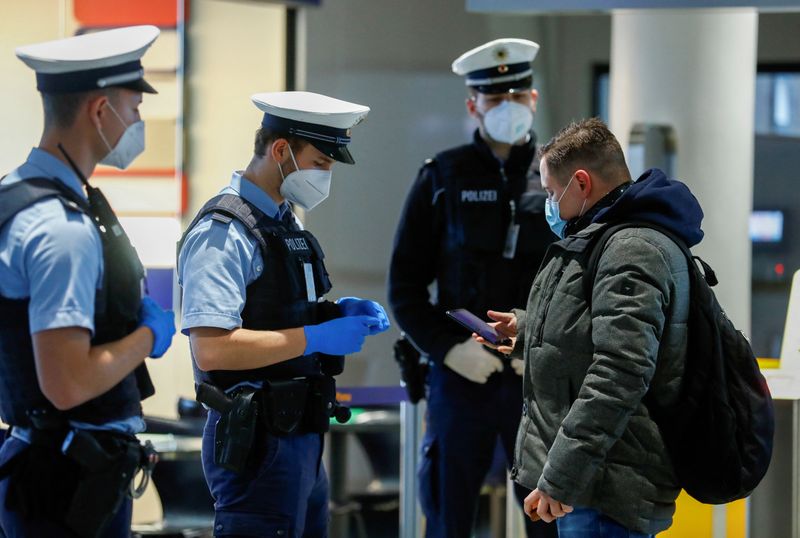 Federal police officers check flight passengers arriving from Britain at