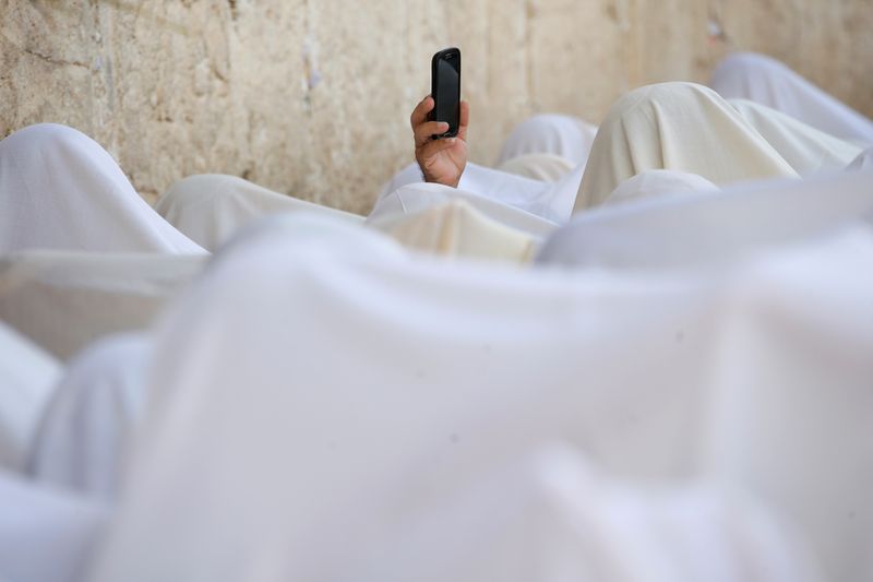 FILE PHOTO: A Jewish worshipper uses his mobile phone to