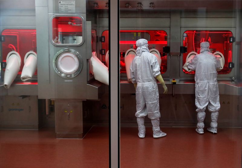 FILE PHOTO: Employees operate a filling machine inside a lab