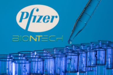 Test tubes are seen in front of displayed Pfizer and