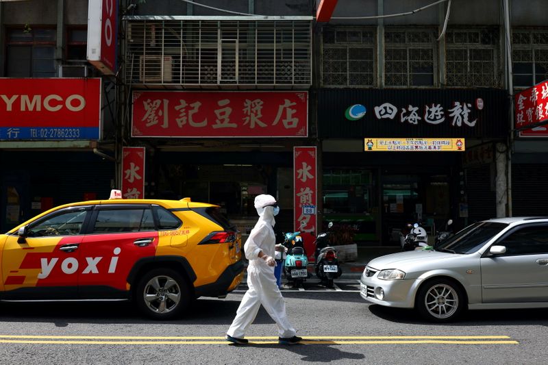 A person dressed in protective suit walks down a street