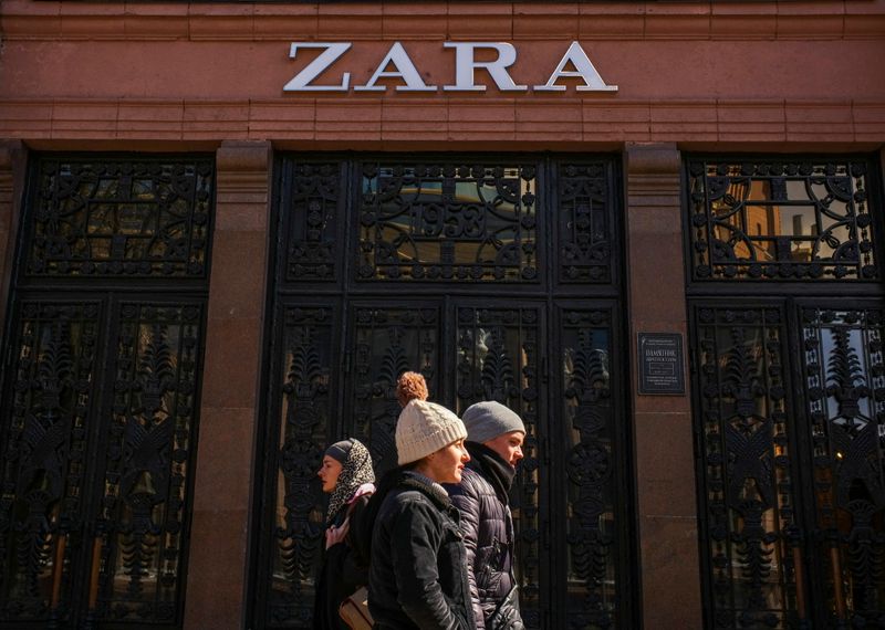 FILE PHOTO: People walk past a Zara store which is