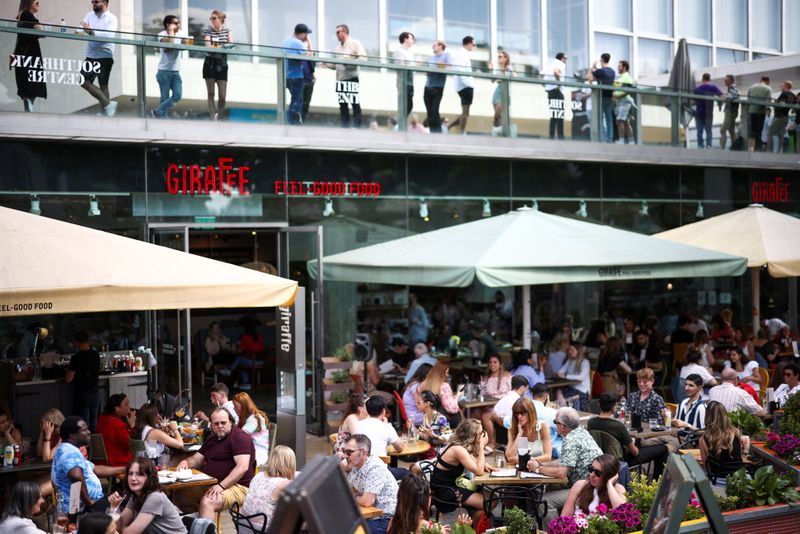 People sit at an outdoor restaurant on the South Bank