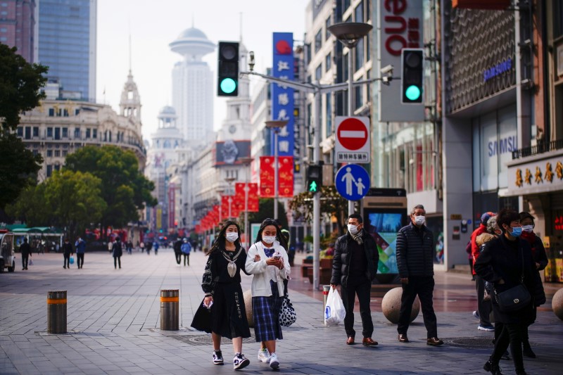FILE PHOTO: People wearing face masks walk at a main