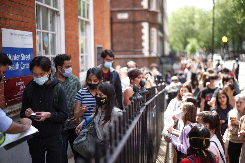 People queue outside a vaccination centre for young people and