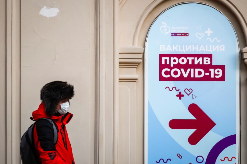 A man walks past a sign outside a vaccination centre