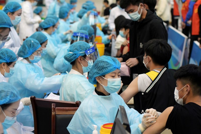FILE PHOTO: Medical workers inoculate students with the vaccine against