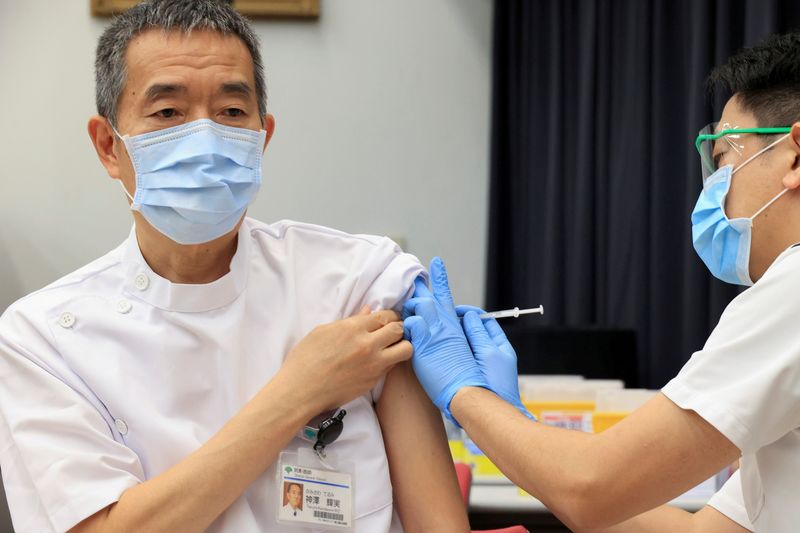 FILE PHOTO: Medical workers receive doses of the vaccine against