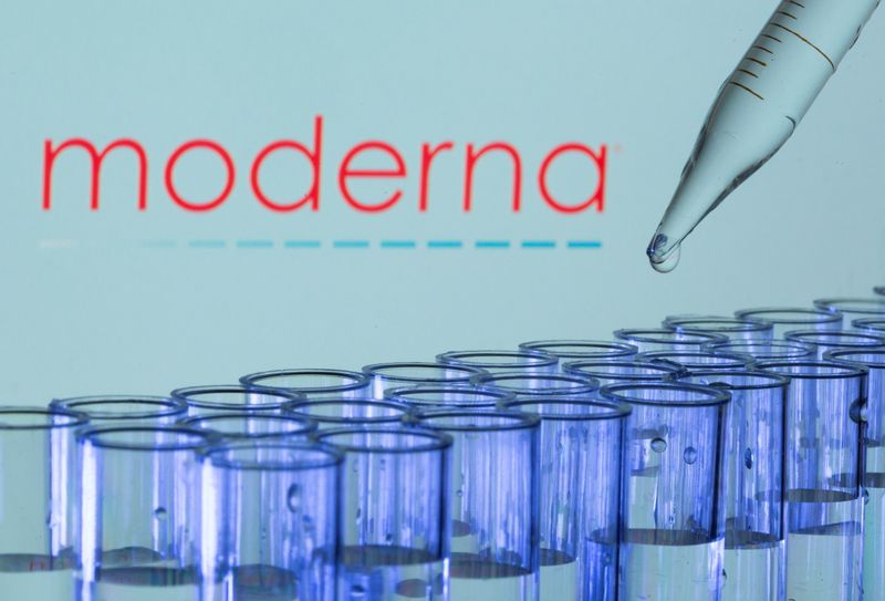 Test tubes are seen in front of a displayed Moderna