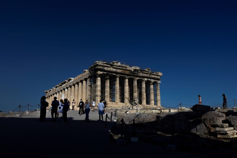 FILE PHOTO: People visit the Parthenon temple atop the Acropolis