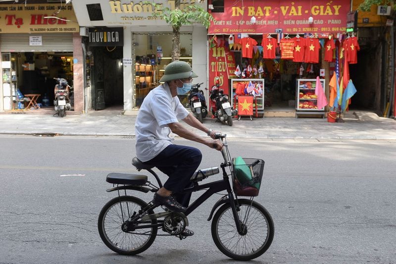 A man rides a bike on an empty street amid